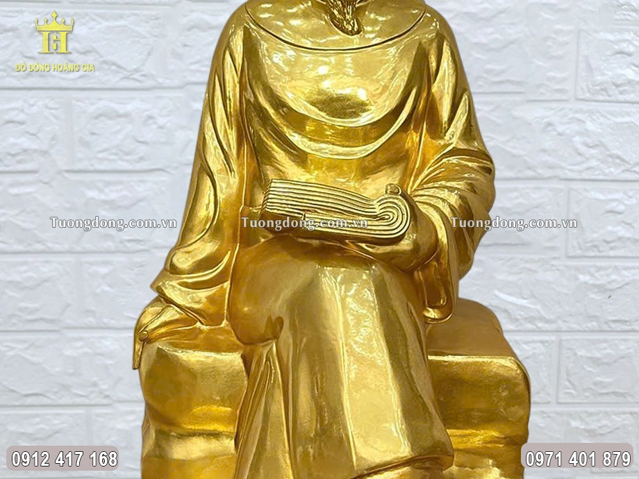 Ông được đúc ngồi trên phiến đá, tay cấm cuốn sách